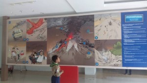 seorang siswa sedang melihat informasi di museum gunung merapi